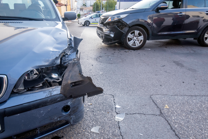 cars that have had an accident with material damage to both cars and a police car blocking traffic